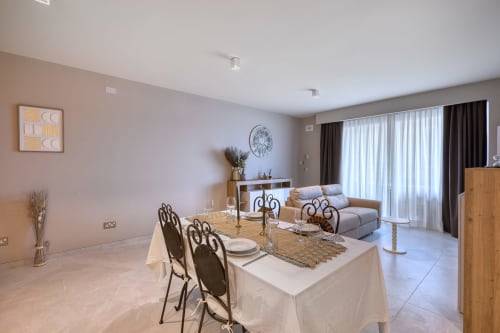 Elegante appartamento con vista mare a Marea Sliema: tavolo da pranzo, divano letto e balcone con affaccio sul mare a Sliema, Malta