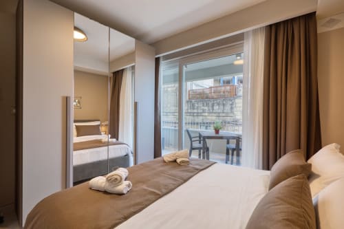 Camera con vista mare moderna a Marea Sliema: armadi specchiati, letto matrimoniale e balcone in vetro con vista su Sliema, Malta