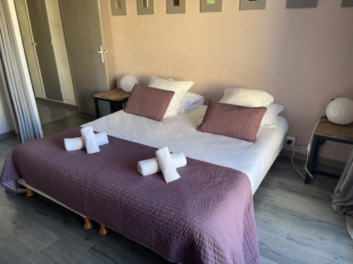 Chambre Côté Jardin at Hôtel l'Orangeraie with twin beds, purple bedding and white pillows