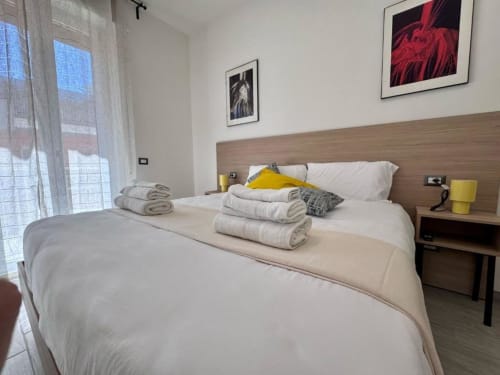 Camera Superior King presso la Costabella Guest House a Vaticano Prati con biancheria bianca, asciugamani arrotolati, dettagli gialli e design moderno