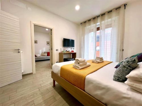 Camera spaziosa con biancheria gialla, TV e accesso al soggiorno presso Costabella Guest House vicino al Vaticano