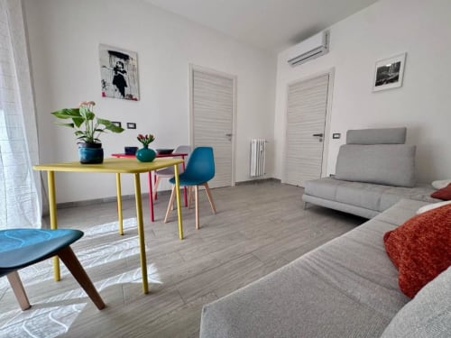 Camera Superior King moderna presso Costabella Guest House in Vaticano Prati con divano grigio, scrivania gialla e arredamento contemporaneo