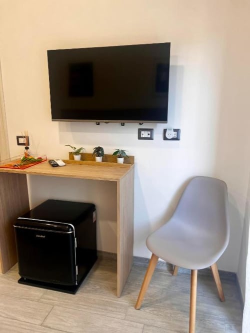 Scrivania moderna nella Superior King Room di Costabella Guest House, Roma, con TV a parete e sedia bianca