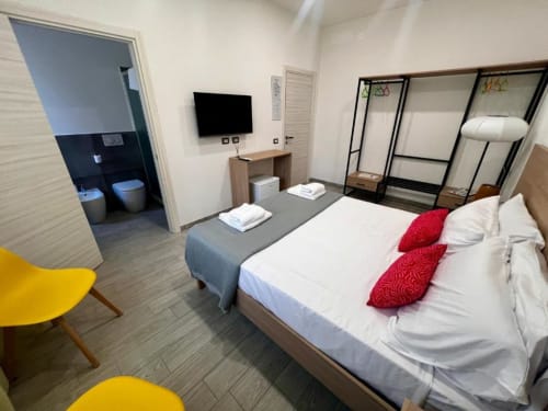Camera da letto matrimoniale moderna a Costabella Guest House nel Prati vaticano con TV schermo piatto, bagno privato e dettagli rossi
