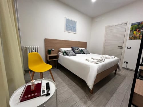 Camera moderna a Costabella Guest House nel Prati vaticano con letto, sedia gialla e arredi contemporanei