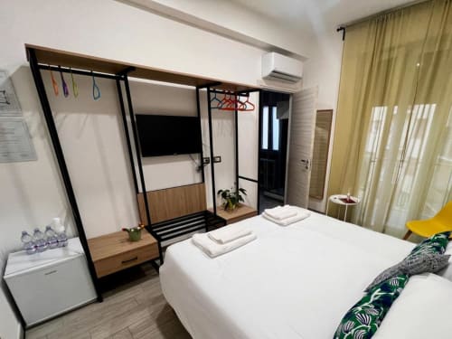 Camera moderna a Costabella Guest House vicino al Vaticano Prati con letto a baldacchino nero, biancheria bianca e design contemporaneo