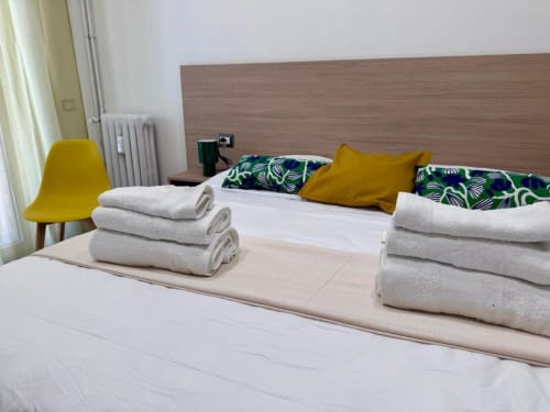 Camera moderna del Costabella B&B con asciugamani freschi, accenti gialli e arredamento tropicale nel Prati vaticano