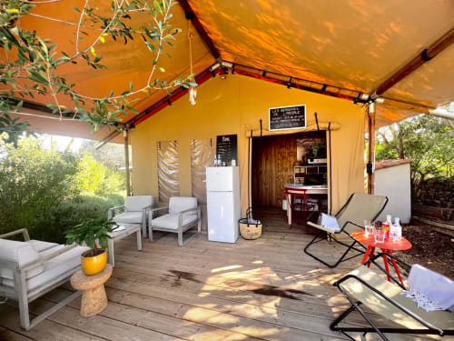 Terrasse de l'Argiale BnB à Figari avec chaises longues, auvent jaune et coin détente confortable
