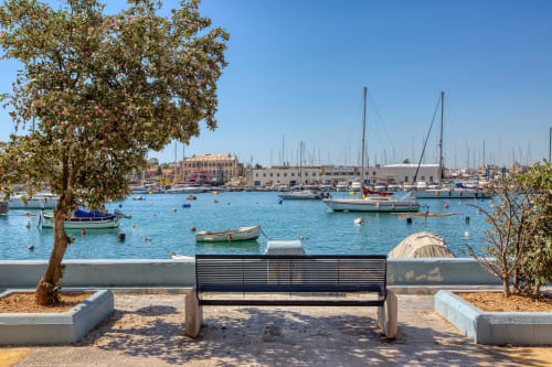 Panchina con vista sul porto mediterraneo e barche a vela a Sliema, Malta, vicino all'hotel Marea
