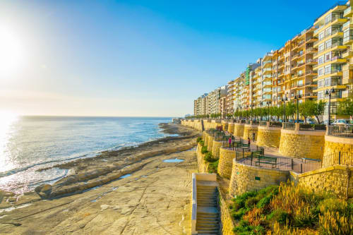 B&B Marea Sliema sulla spiaggia con vista al tramonto sulla costa mediterranea e edifici in pietra gialla, Sliema Malta
