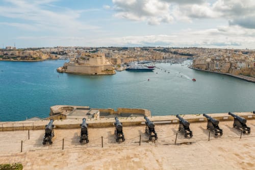Antichi cannoni dominano il Grande Porto con il Forte di Sant'Angelo, l'iconica vista mediterranea di Sliema