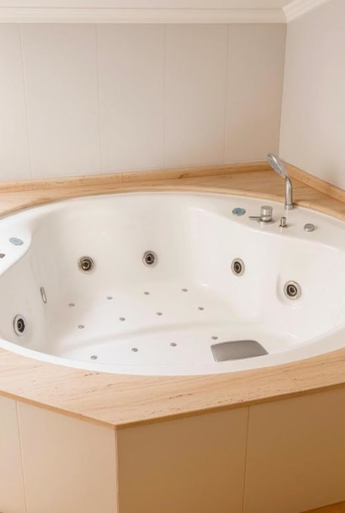 Lujosa bañera de hidromasaje redonda con chorros de agua y marco de madera en la Suite King del Hotel Villa de Cacabelos