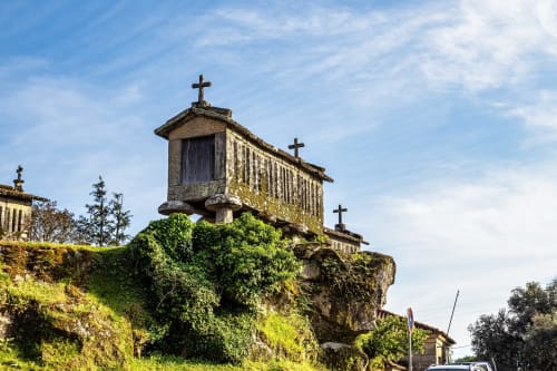 Antigo celeiro de pedra com cruzes em rochas cobertas de musgo na Villas Eden, refúgio rural em Portugal