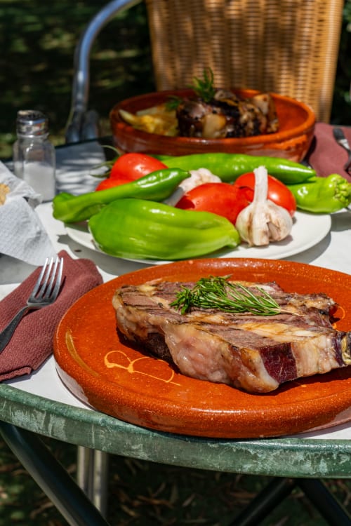 Gegrilde biefstuk met rozemarijn op het terras van restaurant Balcón De Los Montés in Colmenar