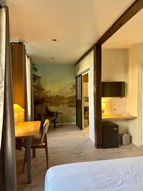 Chambre d'hôtel moderne au Château de la Borde avec espace de travail, télévision et vue murale nature à Ussel