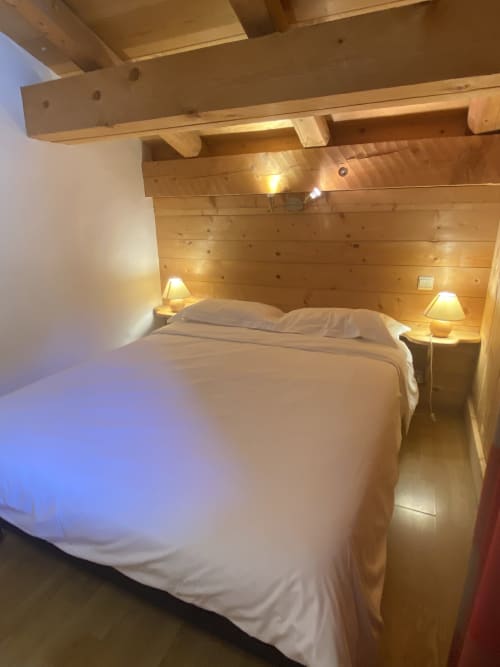 Chambre en bois douillet à La Ferme des Georgières, Notre-Dame-de-Bellecombe, avec literie blanche, poutres apparentes et table de nuit