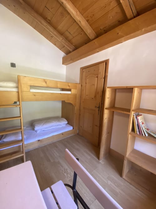 Lit superposé en bois dans chambre de chalet montagnard à La Ferme des Georgières, Notre-Dame-de-Bellecombe, avec poutres apparentes et étagères
