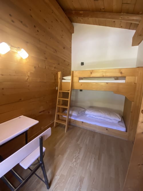 Chambre en bois avec lits superposés, échelle, bureau et banquette à La Ferme des Georgières à Notre-Dame-de-Bellecombe