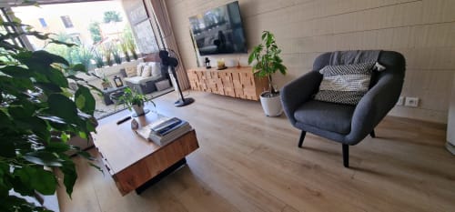 Salon moderne de l'appartement Le 9 Victor Hugo à Aix-les-Bains avec fauteuil gris, mobilier en bois, plantes