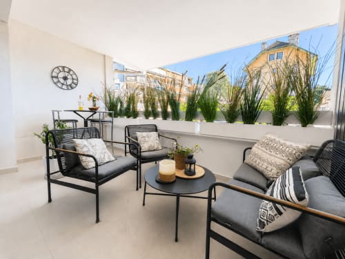 Terrasse moderne du Le 9 Victor Hugo à Aix-les-Bains avec sièges, table ronde, plantes en pots et vue sur la ville