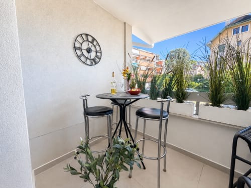 Terrasse moderne du Le 9 Victor Hugo, Aix-les-Bains avec table haute, plantes décoratives et vue sur la ville