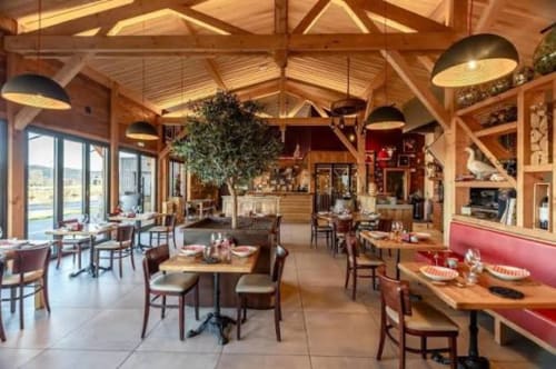 Les Gites de Campardon dining room in Monties with wooden beams, tables set for service, and panoramic windows