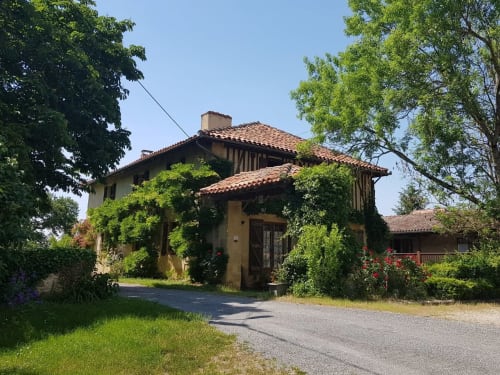 Rustic stone villa at Les Gites de Campardon in Monties, France, with terracotta roof and ivy-covered facade surrounded by