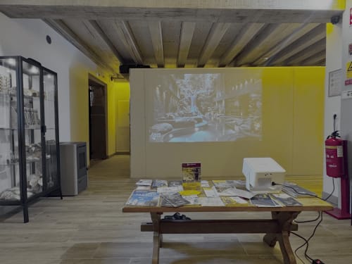 Albergue Santiago de Caminha hostel common room with yellow walls, wooden table with travel guides, and projected street