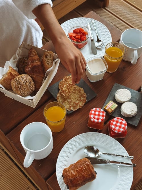 Continental breakfast spread at You & Me Glamping in Moncontour with pastries, fresh strawberries, cheese, and juice