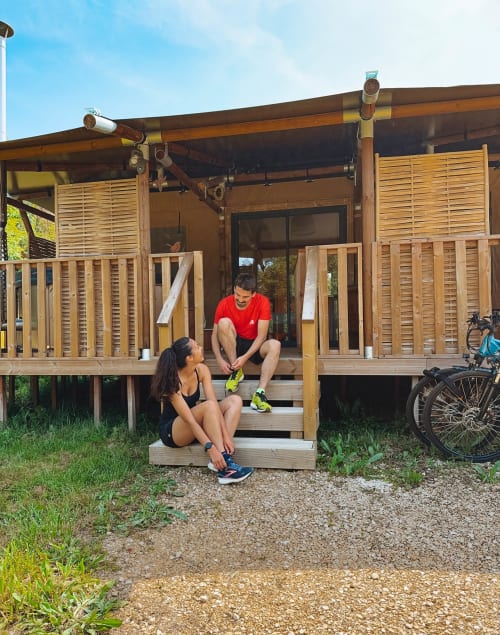 Couple relaxing at You & Me Glamping wooden cabin in Moncontour with bikes nearby