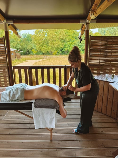 Massage therapist treating guest on wooden deck at You & Me Glamping, Moncontour, overlooking countryside
