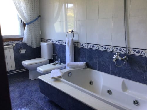 Baño de spa con bañera de hidromasaje, inodoro y lavabo en la casa rural Houses by Pilar en Soutomaior, España