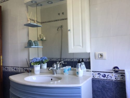 Baño moderno con lavabo curvo, azulejos decorativos azules y espejo en la casa rural Houses by Pilar de Soutomaior