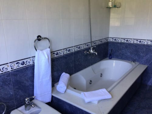 Baño de lujo en la casita Houses by Pilar, Soutomaior, con toallas blancas y detalles decorativos de azulejos azules alrededor de elementos modernos