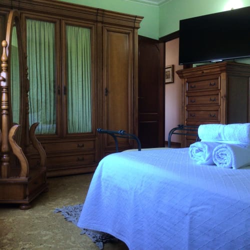 Dormitorio Aranza Descanso Natural en la casa rural Houses by Pilar de Soutomaior con muebles de madera y vistas a la montaña