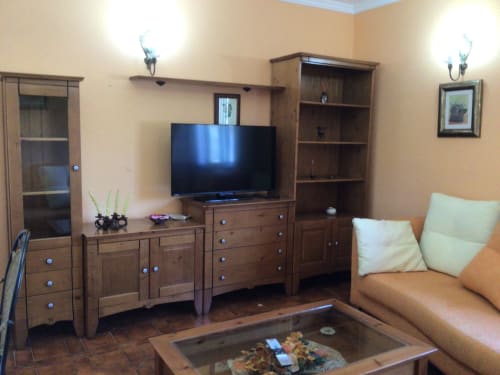 Acogedora sala de estar de cabaña en Houses by Pilar con muebles de madera, TV y cómodos asientos en Soutomaior