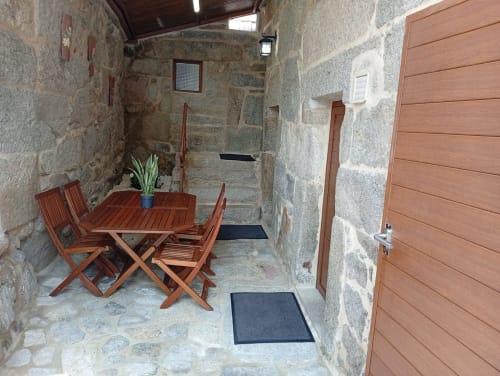 Patio rústico de piedra en Houses by Pilar con juego de comedor de madera y plantas, Soutomaior