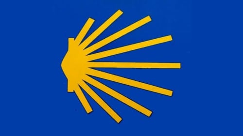 Símbolo de concha de vieira amarilla sobre fondo azul, logo del alojamiento rural Turismo Rural O Vilar en A Coruña, España
