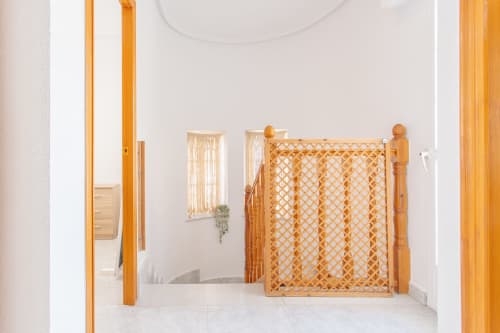 Sala de juegos moderna en blanco con puerta de seguridad de madera y cortinas en Villa Hammely, cabaña en Cartagena