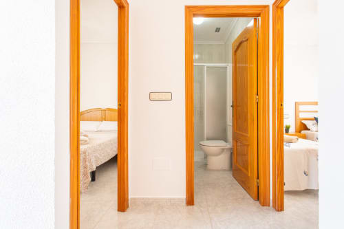 Pasillo de la villa Hammely en Haus Holiday Homes, Cartagena, con puertas de madera a dormitorios y baño con vista al mar