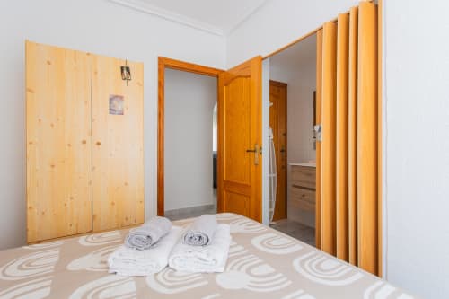 Dormitorio espacioso en Villa Hammely, cabaña de Cartagena con armarios de madera, toallas blancas y pisos estampados