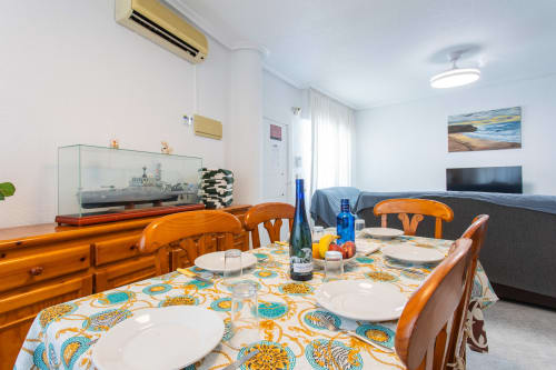 Comedor luminoso con mesa de madera y mantel estampado colorido en Villa Hammely, alquiler de cabaña en Cartagena con vistas al mar
