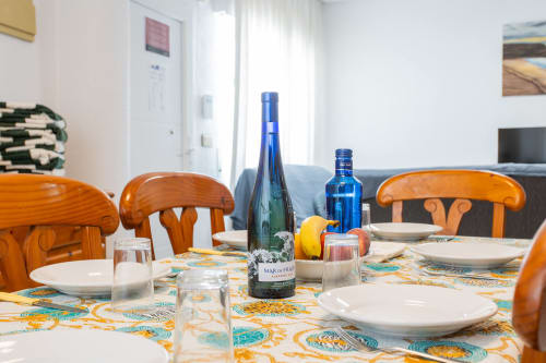 Comedor de Villa Hammely en Cartagena con sillas de madera, mantel colorido, botellas de vino y mesa preparada