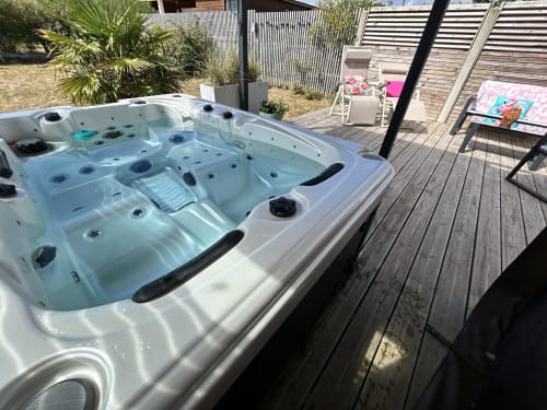 Outdoor hot tub on wooden deck at La Villa Plein Vent cottage in Barneville-Carteret