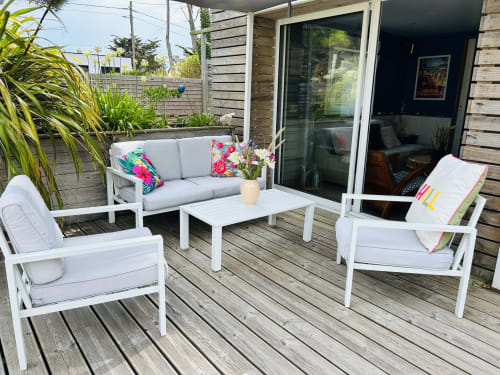 White patio furniture with cushions on wooden deck at La Bounty cottage, Barneville-Carteret