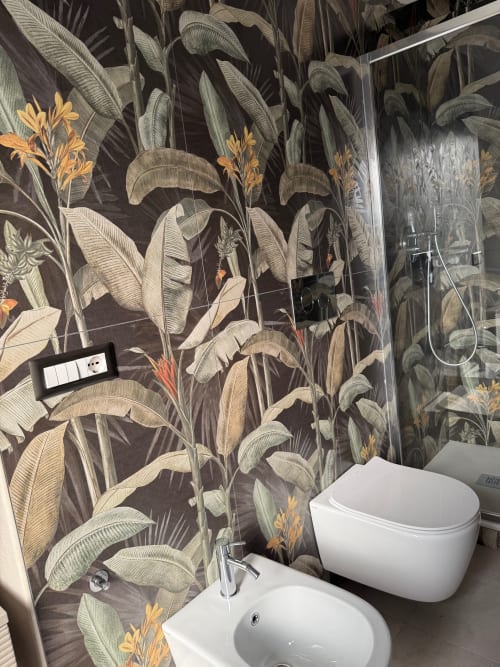 Modern bathroom at BellDuomo Suite Messina with botanical wallpaper, white fixtures, and glass shower enclosure