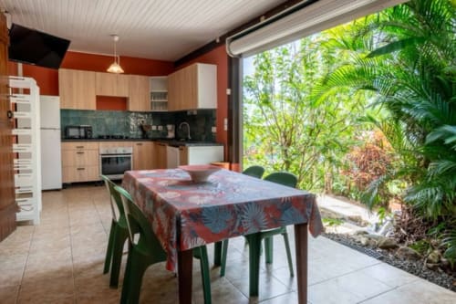 Cuisine et salle à manger modernes aux Gîtes Bagatelle, Sainte-Rose, avec vue sur le jardin tropical
