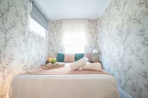 Acogedora habitación en Luxer Holidays Málaga con paredes de mármol, luz natural y mobiliario moderno