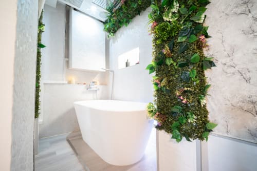 Baño moderno en apartamento Luxer Holidays Glow, Málaga, con bañera exenta blanca y pared verde viva