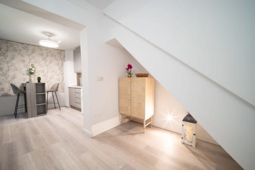 Luminoso apartamento en Málaga con suelos de madera clara, claraboya, armario de madera y zona de estar moderna